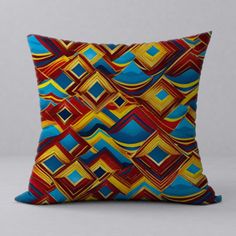 a colorful pillow with blue, yellow and red squares on it's side in front of a gray wall