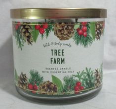 a candle with pine cones and berries on the label that says, tree farm scented candle