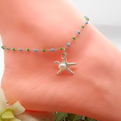 "Adorable ocean blue and green beaded chain anklet adorned with sterling silver starfish and wire wrapped fresh water pearl. Fits up to 9.5\" ankles and is the perfect accessory for summer and beach attired. Having a beach wedding? These are adorable for your bridesmaids! Symbolism: --Starfish are stars that fell from the sky into the ocean. Represents the Virgin Mary, deep divine love, inspiration, intuition, safe travels over water, healing and regeneration of the spirit --Silver deals with th Summer Anklet With Starfish Charm As Gift, Blue Anklets With Starfish Charm For Gift, Blue Anklets With Starfish Charm As Gift, Turquoise Starfish Charm Anklet As Gift, Turquoise Anklet With Starfish Charm As Gift, Blue Beaded Starfish Anklet, White Starfish Anklets As Gift, White Starfish Anklets For Gift, Silver Anklets With Starfish Charm For Beach