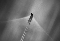 a man standing in the middle of an airplane trail