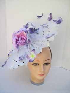 "* This pleated polka dot hat base has a 14\" diameter and has an overlay of shredded white horsehair with purple Hydrangea petals scattered about. In the center are two pink silk roses with purple highlights. * On a satin covered acrylic headband it is secure, well balanced and comfortable to wear for extended periods of time. * Upon ordering you will receive this exact headpiece. * Perfect for this Season's Derby events, ladies luncheon and gatherings, fashion show, wedding, wedding shower or Purple Mini Hats For Spring Races, White Fitted Flower Hats, Fitted White Flower Hats, White Costume Hats And Headpieces For Spring Races, White Costume Hats For Spring Races, Purple Summer Fascinator With Handmade Flowers, Purple Fascinator With Handmade Flowers For Spring, Purple Fitted Fascinator For Spring, White Flower Hat For Royal Ascot