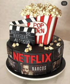 a birthday cake made to look like a movie set with popcorn and movies on top