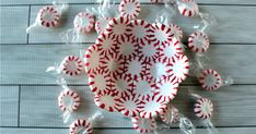 red and white paper plates with candy canes around them on a wooden table top