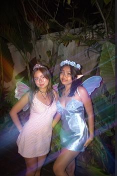 two girls dressed in fairy costumes posing for the camera