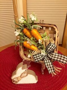 some carrots are sitting in a basket on top of a red tablecloth with ribbon