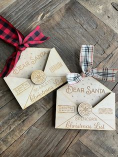 two wooden christmas tags with red and black plaid ribbon on wood planks next to each other