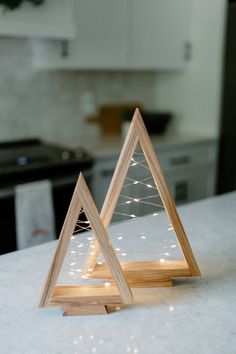 two wooden christmas trees sitting on top of a white counter