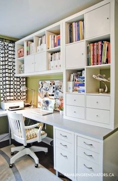 a white desk sitting under a window next to a book shelf