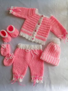 a pink knitted baby outfit and booties