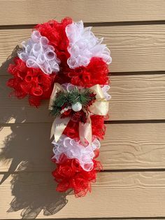 a red and white wreath on the side of a house