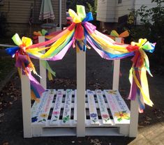 a wooden bench decorated with ribbons and flowers