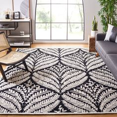 a black and white rug in a living room with a chair next to the couch