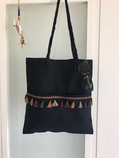 a black handbag hanging from a door