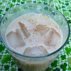 a glass bowl filled with ice cream on top of a green and white checkered table cloth