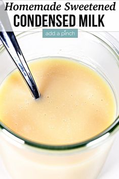 homemade sweetened condensed milk in a small glass bowl with a spoon sticking out of it