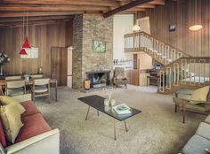 a living room filled with furniture and a fire place in the middle of an open floor plan