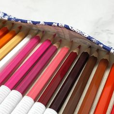 many different colored pencils lined up in a bag