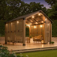 a wooden gazebo sitting on top of a patio next to a lush green field