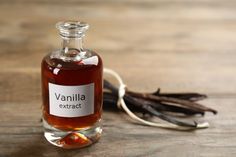 a bottle of vanilla extract next to some vanilla pods