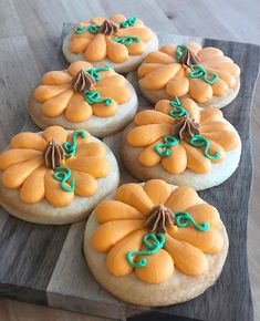 several decorated cookies sitting on top of a wooden cutting board