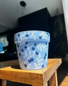 a blue flower pot sitting on top of a wooden table