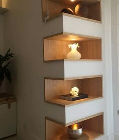 three shelves with vases and books on them