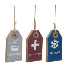 three wooden tags with snowflakes and ski lodge symbols hanging from twine strings