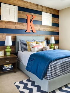 a bedroom with blue and white bedding, wooden headboard and wall art above the bed