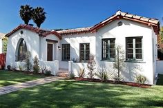 a white house with red tile roof and windows