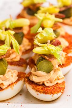 deviled eggs topped with pickles and other toppings