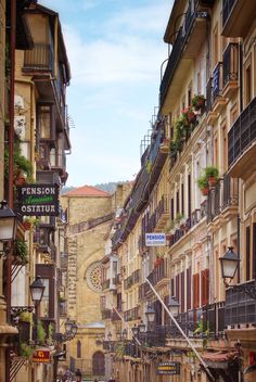 an alley way with several buildings and people walking down the street in front of them