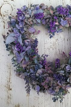 a heart shaped wreath with purple flowers on it and the words passoa feliz