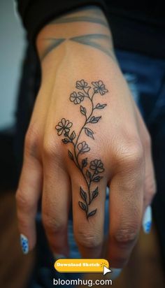 a woman's hand with a flower tattoo on it