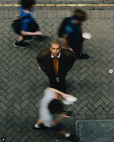 an overhead view of people walking down the street, with one man wearing a suit and tie