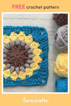 several balls of yarn sitting next to each other on top of a white table with a crocheted square