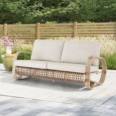 a couch sitting on top of a patio next to a potted plant