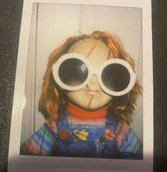 an old photo of a creepy doll with large round glasses