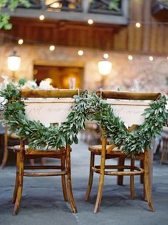 two wooden chairs with wreaths on them