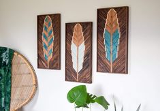 three wooden arrows are hanging on the wall next to a potted plant and a wicker basket