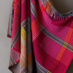 a multicolored blanket hanging up against a wall