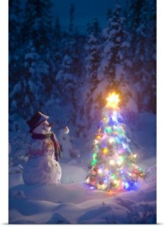 a snowman standing next to a lit christmas tree in the middle of a snowy forest