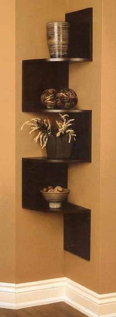 three tiered shelves with pots and bowls on them in the corner of a room