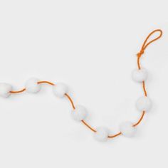 an orange string with white balls on it