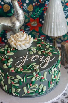 a decorated christmas cake sitting on top of a table next to a silver deer statue