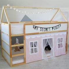 a dollhouse bed with a cat in the middle and a tent on top that says my secret place