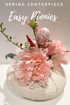 a vase filled with pink flowers on top of a white table cloth covered in text reading spring centerpiece easy peonies