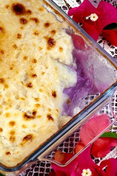 a casserole in a glass dish with flowers around it