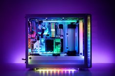 the inside of a computer case lit up with purple lighting and colorful lights on it