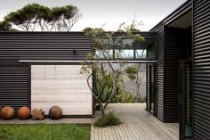 an outside view of a modern house with wooden floors and black siding on the walls