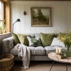 a living room filled with furniture and a painting hanging on the wall above it's windows